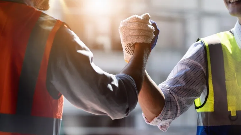 Bouw- of technische groep en werknemer Teamwerk en vastberadenheid om te slagen Veiligheidshelm om ongelukken tijdens het werken te voorkomen