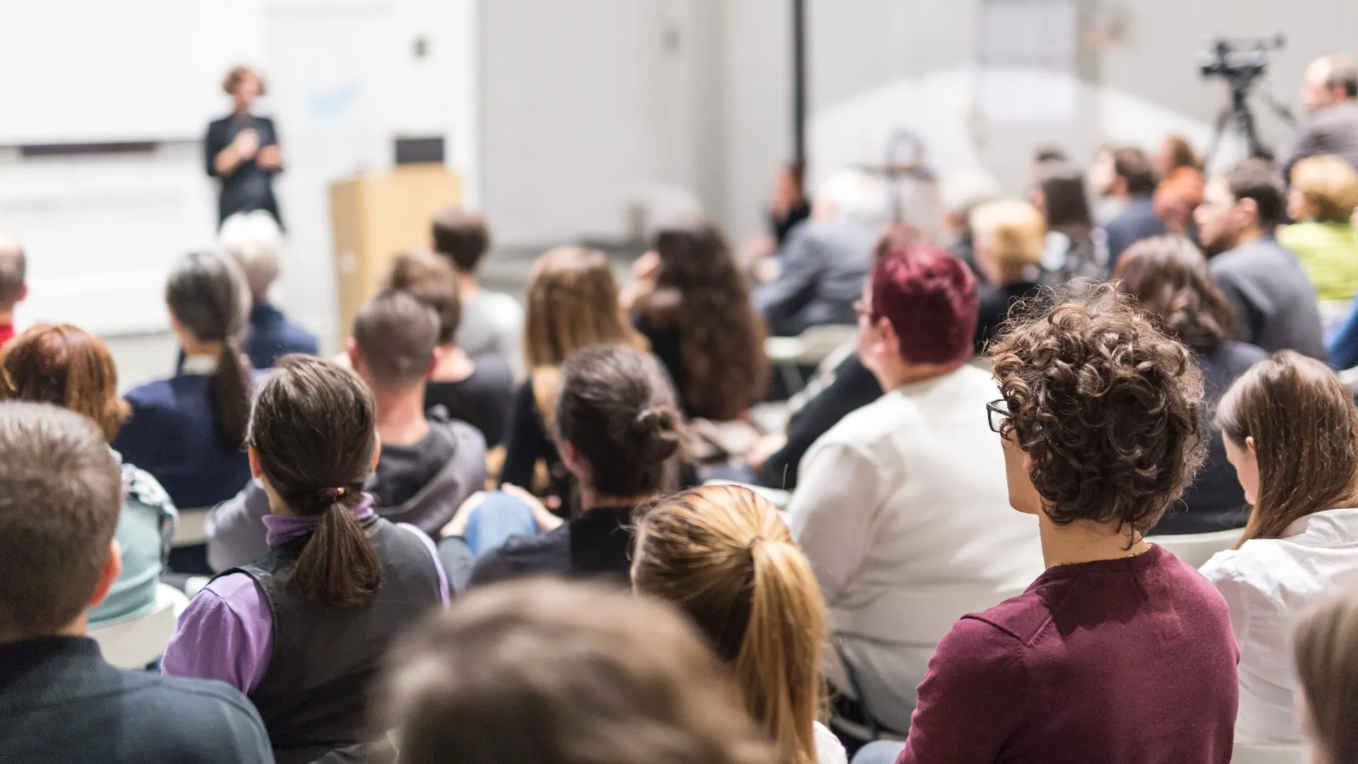 Vrouwelijke spreker die presentatie geeft in collegezaal