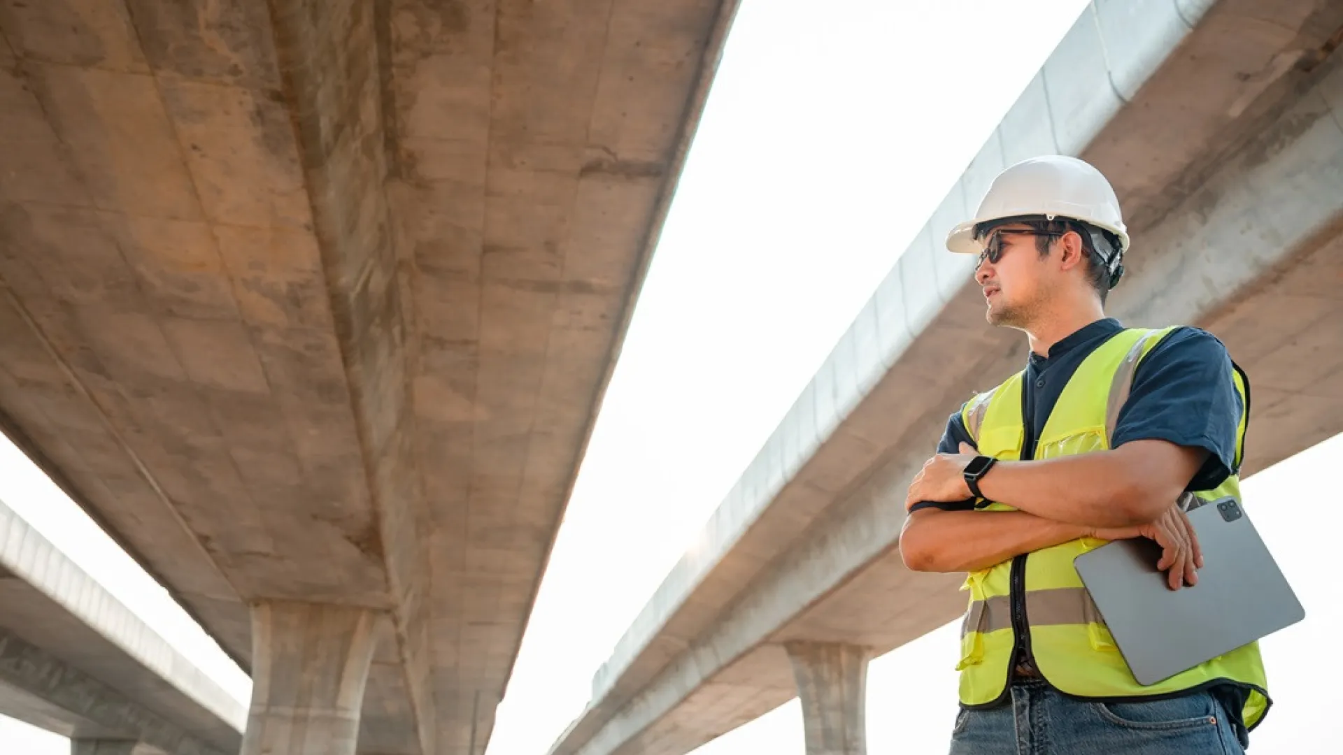 Aziatische mannelijke ingenieur die werkt bij het plannen van een bouwproject Ingenieur die toezicht houdt op de bouw van een betonnen brug op een bouwplaats