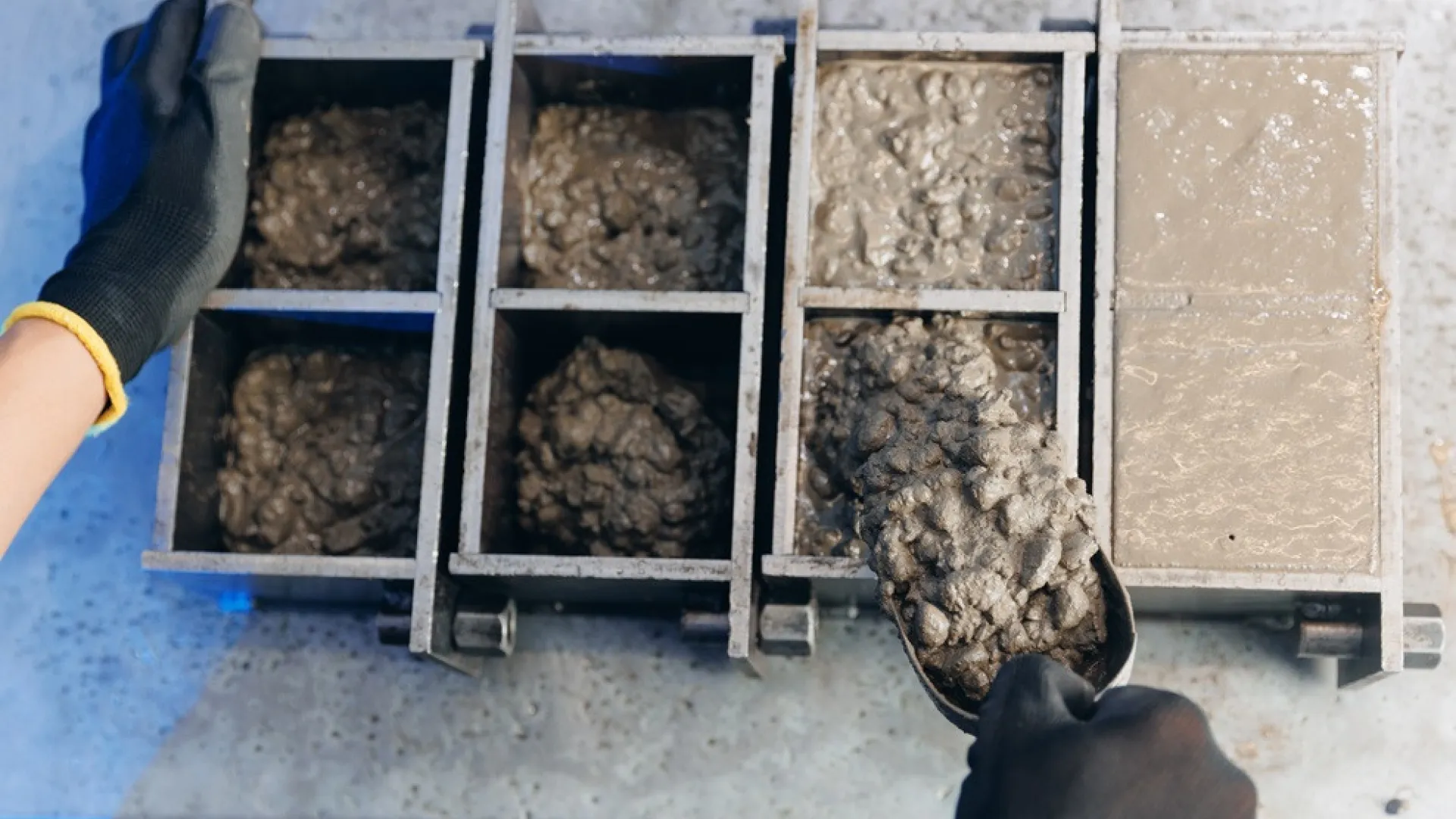 Werknemer maakt betonnen kubussen in stalen mal controle van kwaliteit cement in het laboratorium
