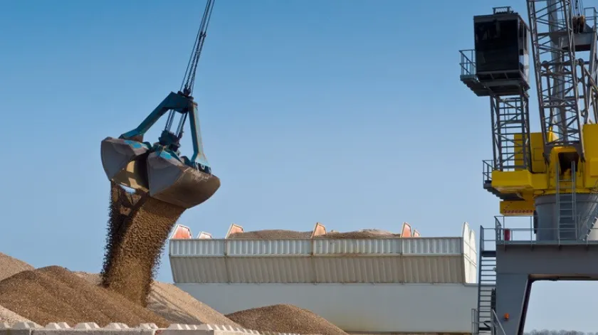 Grote gele havenkraan lost grind van een schip