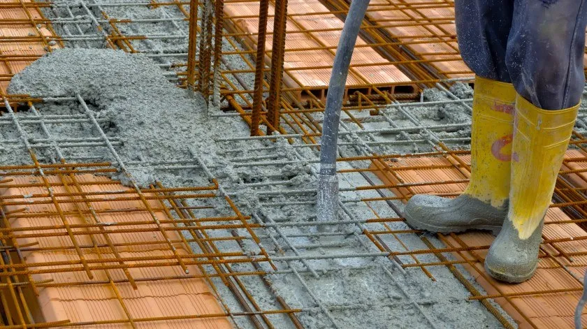 bouwvakker die vloeibare cement comprimeert