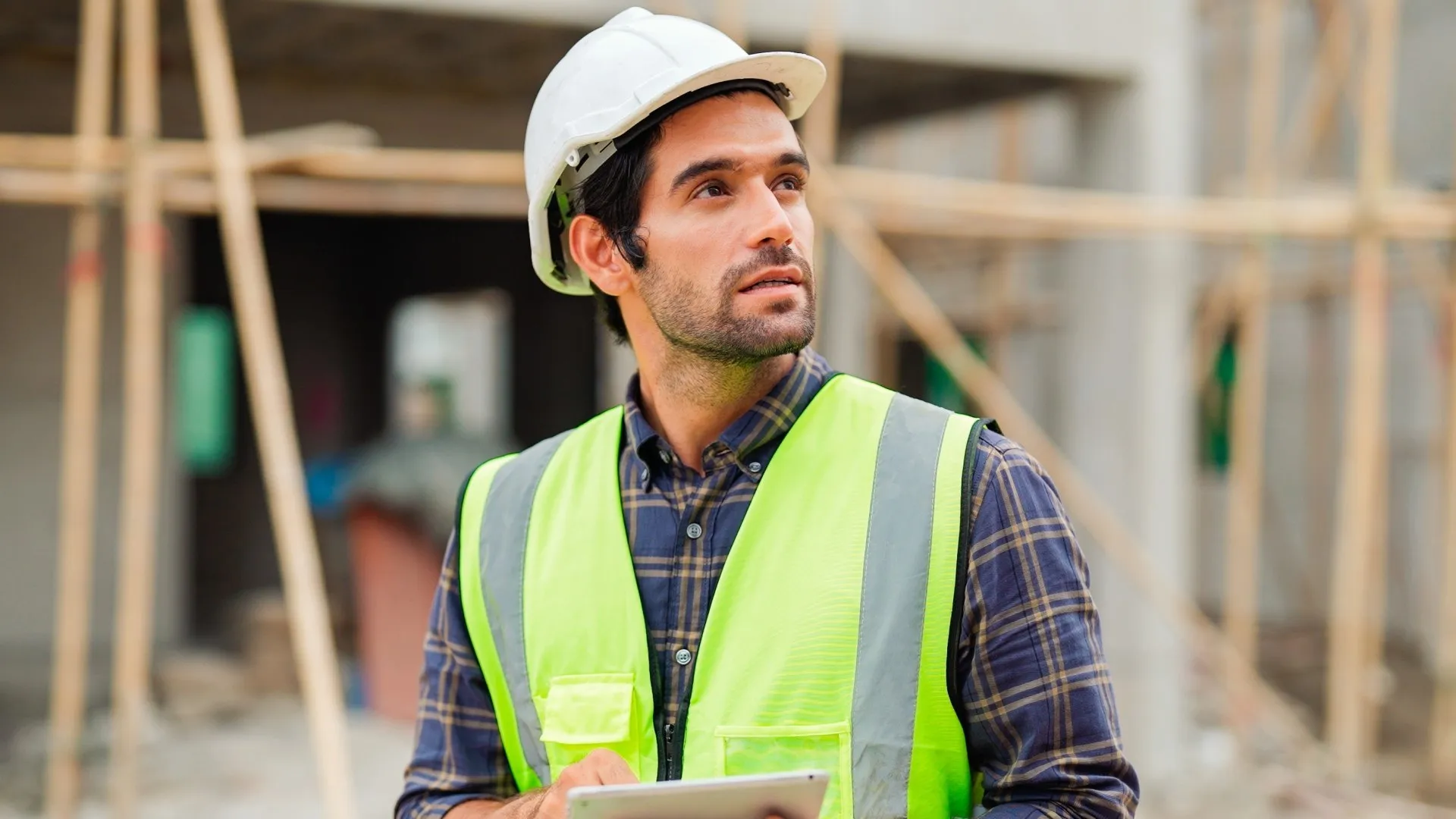 Portret van een civiel ingenieur met helm en hesje op een bouwplaats