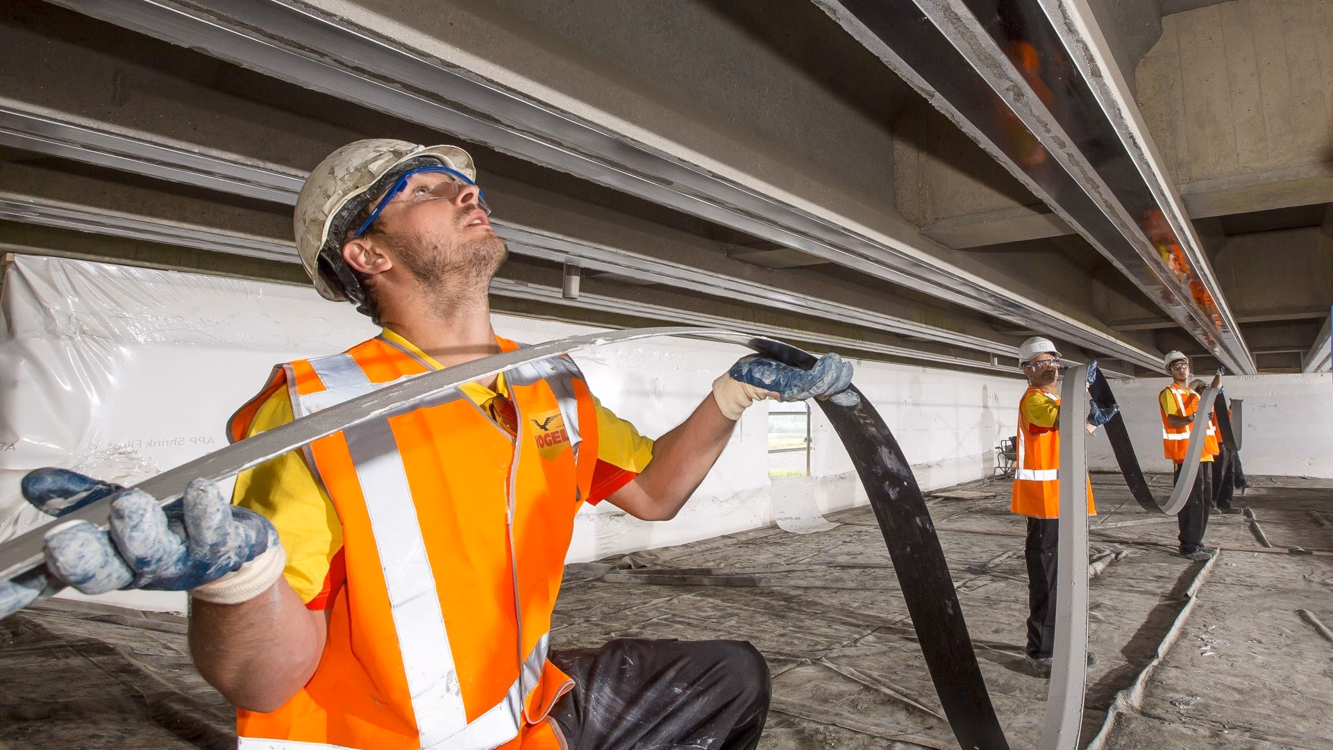 Medewerkers met helm en hesje brengen titaniumstrips aan voor kathodische bescherming