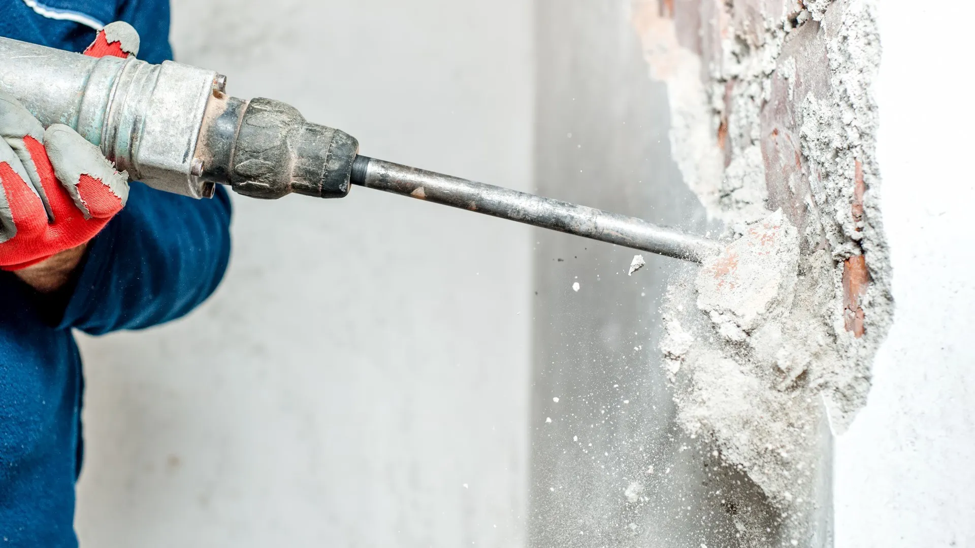 Medewerker boort met een drilboor in een betonnen wand