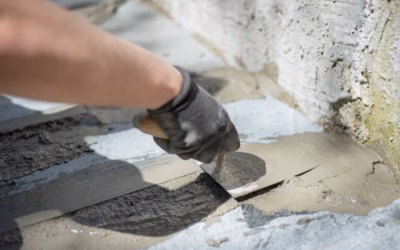 Medewerker voert een handmatige reparatie van beton uit met mortel en troffel
