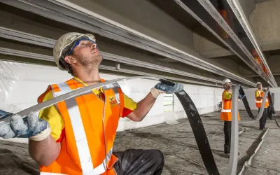 Medewerkers met helm en hesje brengen titaniumstrips aan voor kathodische bescherming