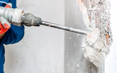 Medewerker boort met een drilboor in een betonnen wand