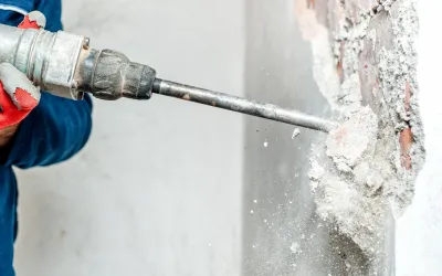 Medewerker boort met een drilboor in een betonnen wand