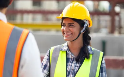 Ingenieur met een gele helm en hesje op een bouwplaats