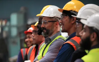 Een team van ingenieurs met helmen, veiligheidsbrillen en hesjes.