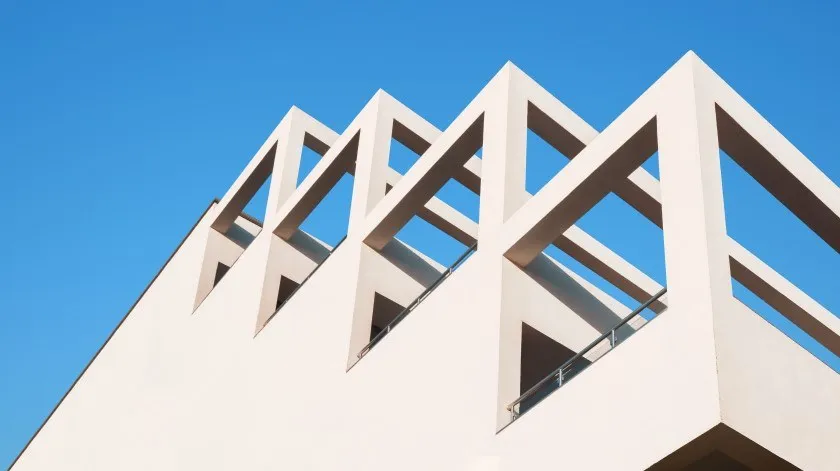 Moderne betonnen architectuur met strakke lijnen tegen een blauwe lucht