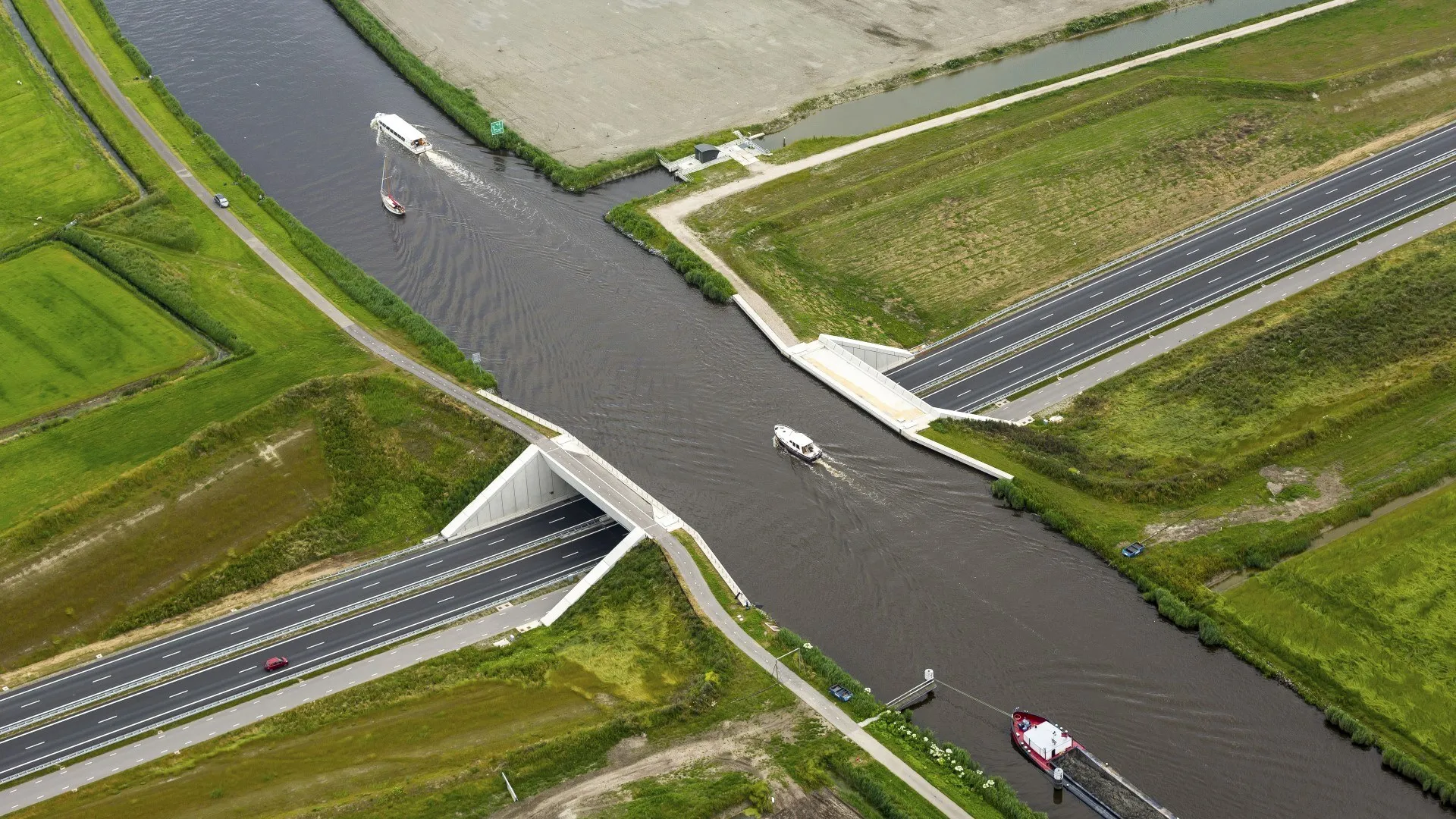 luchtfoto van betonnen aquaduct in de N31 onder een kanaal in Friesland