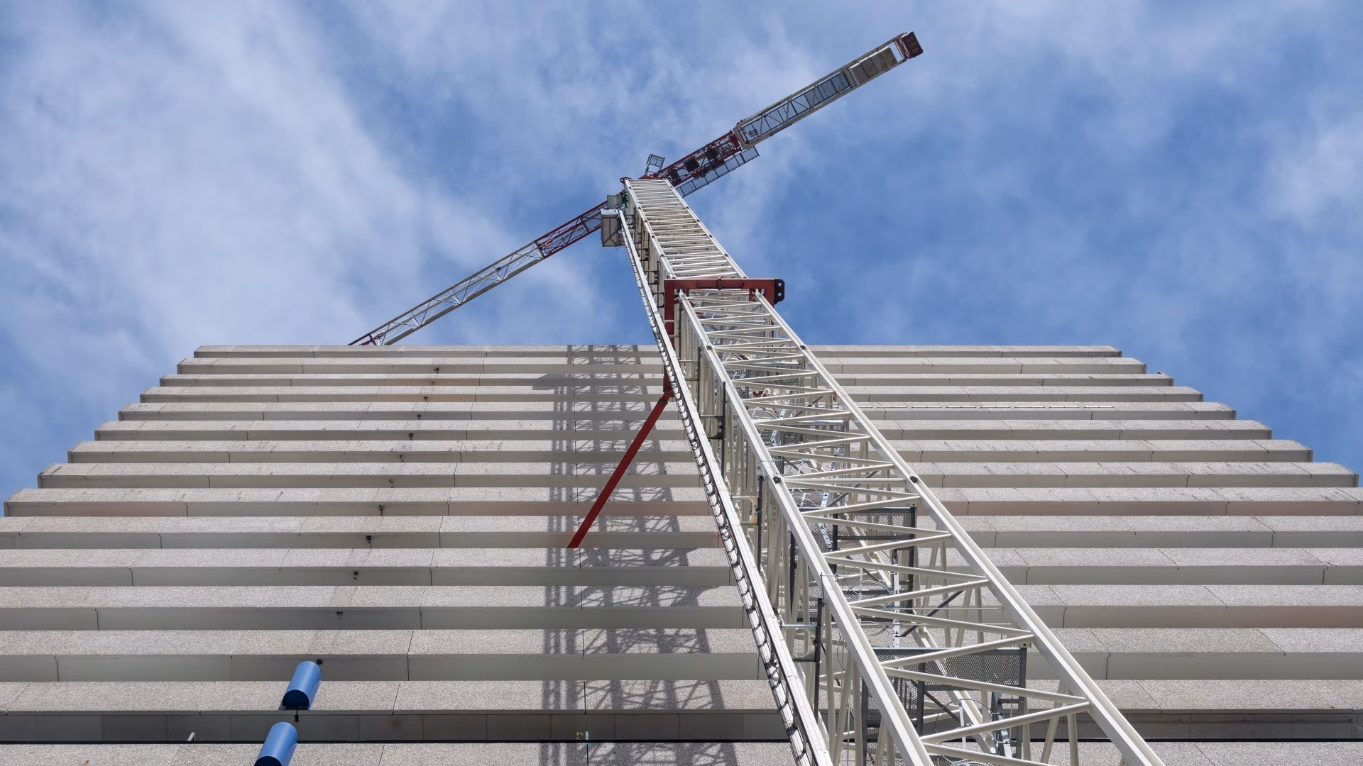 Hoog Nederlands kantoorgebouw met bouwkraan eraan vast