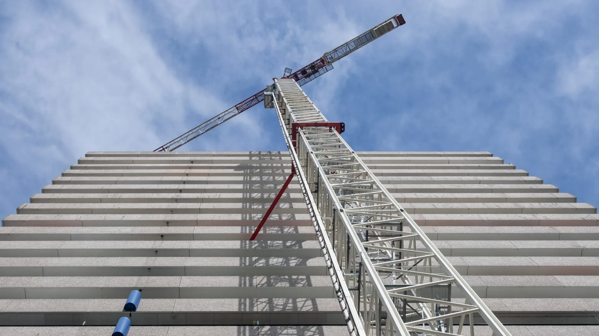 Hoog Nederlands kantoorgebouw met bouwkraan eraan vast